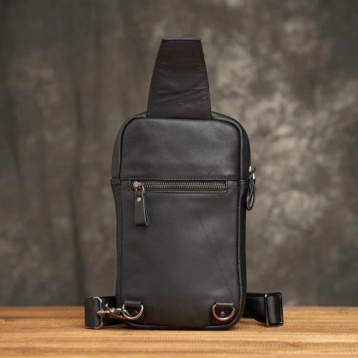 Gros plan d'un sac banane homme en cuir noir, affichant la texture du cuir