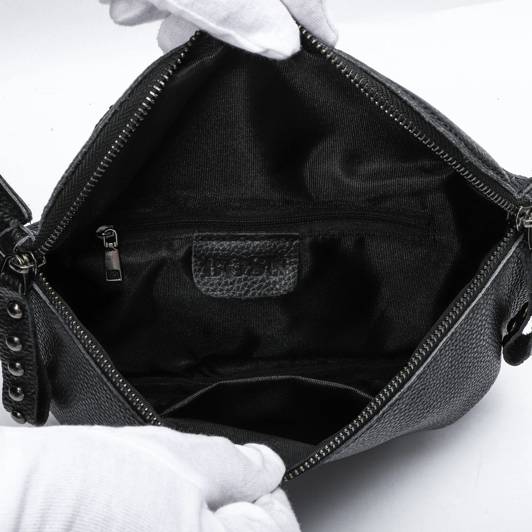 Sac banane femme en cuir noir porté en bandoulière, idéal pour une touche élégante.