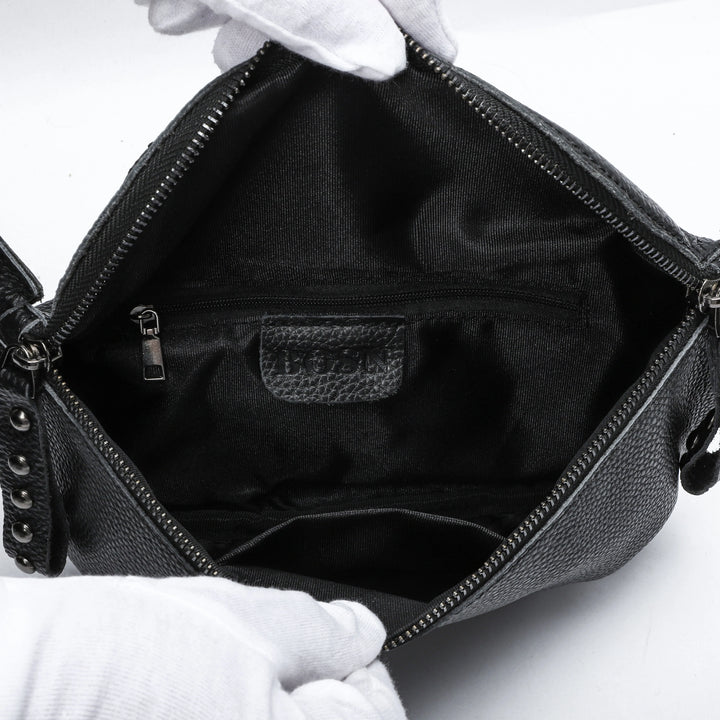 Sac banane femme en cuir noir porté en bandoulière, idéal pour une touche élégante.