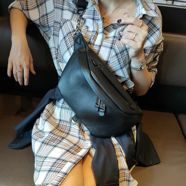 Sac banane élégant en cuir pour femmes, couleur noire, porté en bandoulière, idéal voyage et mode.