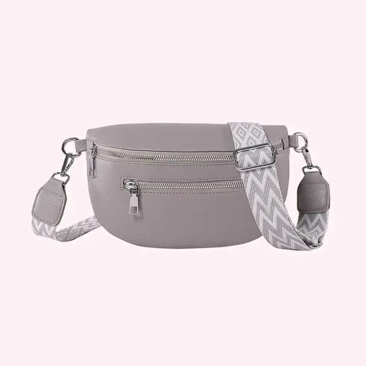 Sac banane élégant en cuir PU gris pour femme, porté en bandoulière, idéal accessoire mode.