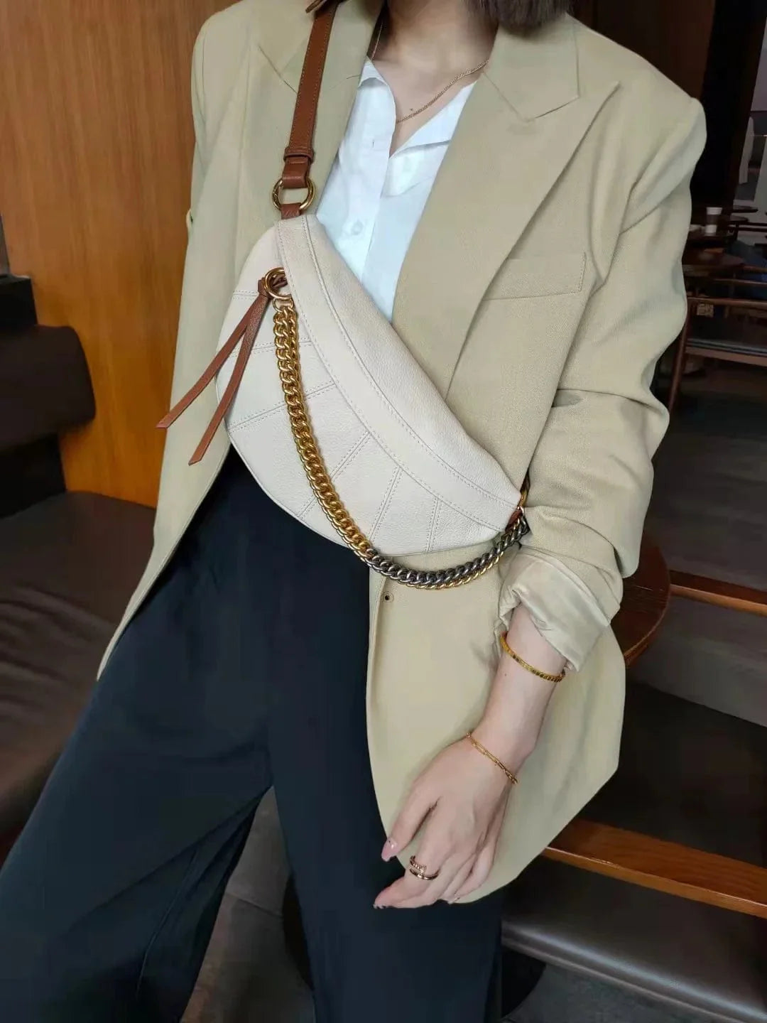 Sac banane en cuir noir posé sur une surface, mettant en valeur son design épuré et chic