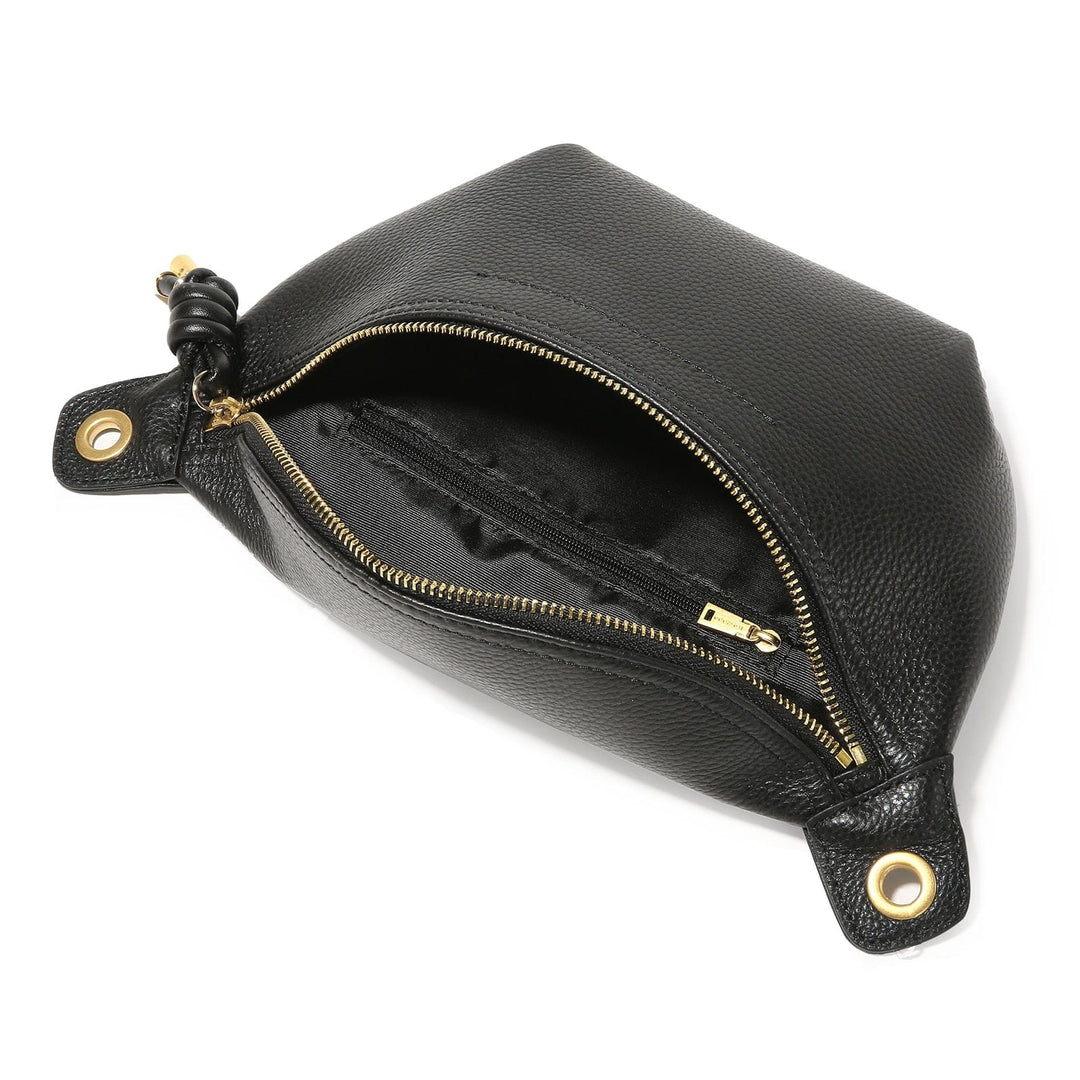 Sac banane stylé en cuir noir lisse, porté en bandoulière, soulignant un look moderne et féminin.