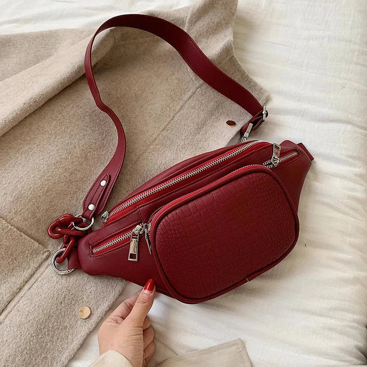 Sac bandoulière rouge en faux cuir, modèle banane compact et élégant, idéal pour compléter une tenue femme.