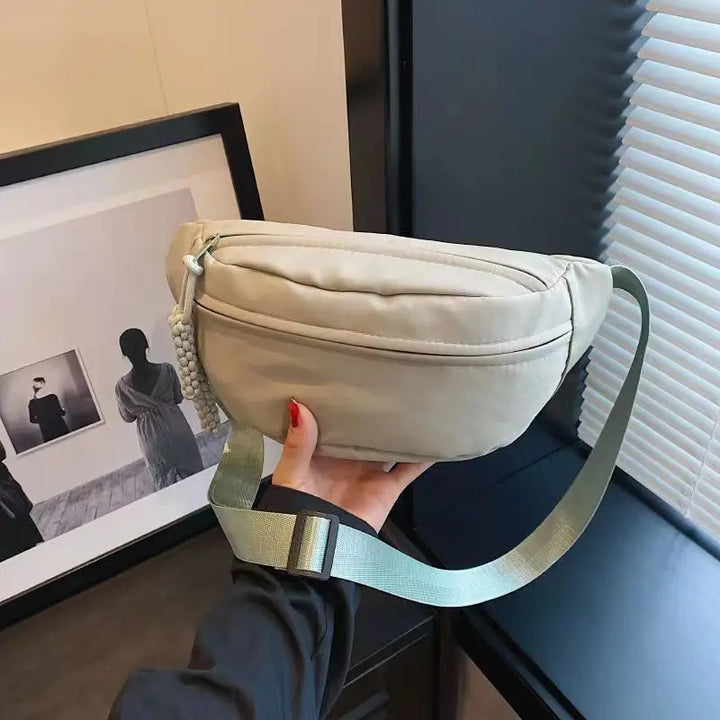 Accessoire de mode féminin: sac banane en tissu chic, idéal pour compléter un look moderne.