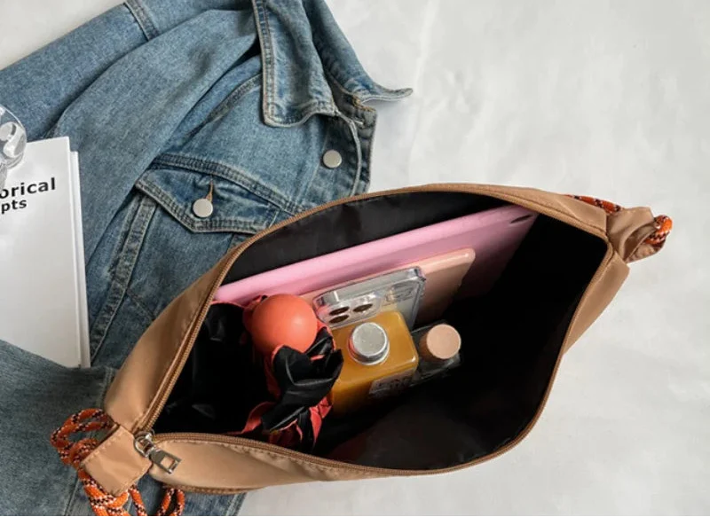 Sac banane en toile grise pour femme, avec détails métalliques et ceinture ajustable, style urbain chic.