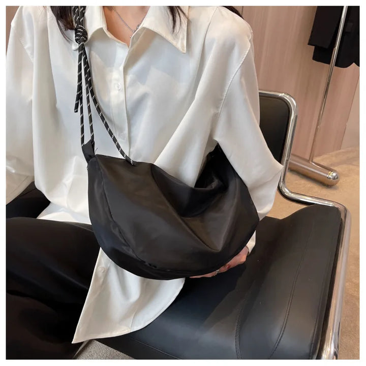 Sac banane mode femme en toile beige avec fermeture éclair contrastante, style décontracté et moderne.
