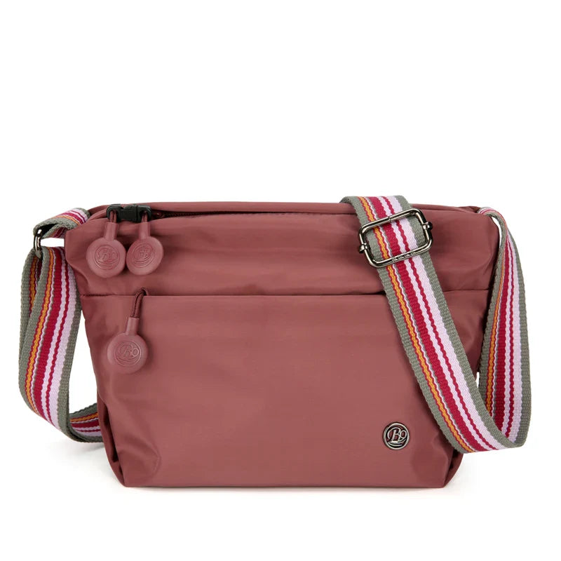 Sac banane noir, fermé, porté en bandoulière par une femme, léger et sécurisé pour le voyage