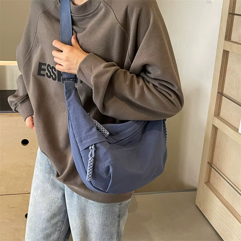 Sac banane femme noir oversize en nylon, bandoulière ajustable, pour un style urbain moderne.