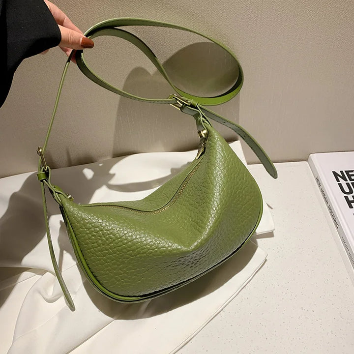 Sac banane vert femme en similicuir, élégant et moderne, porté en bandoulière pour un look décontracté chic.