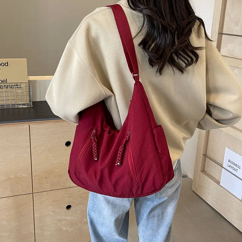 Sac bandoulière besace léger en nylon noir pour femme active, idéal quotidien et voyage.