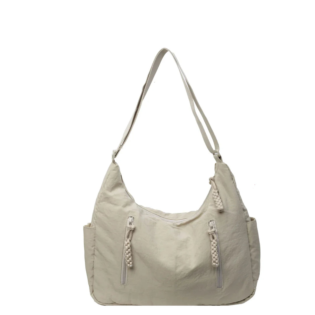 Sac besace en nylon noir, léger et tendance, un accessoire indispensable pour la femme active et organisée.