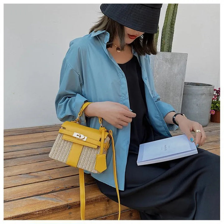 Sac bandoulière en raphia naturel, forme carrée structurée avec bordures en cuir marron