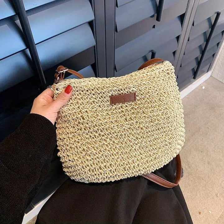 Bandoulière femme chic en paille tressée, finitions en cuir végan sophistiquées.