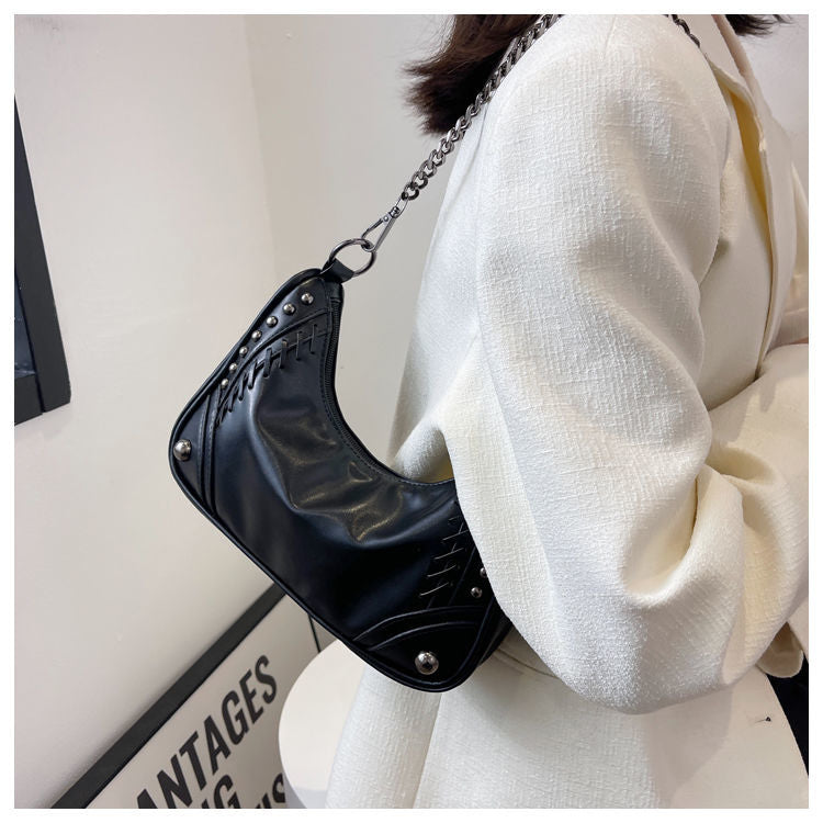 Besace noire cloutée en PU pour femme, design rebelle. Sac bandoulière chic, parfait accessoire urbain.