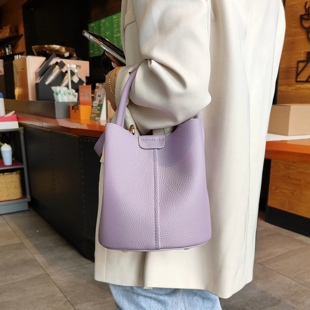 Sac femme luxe en cuir, style seau, offrant espace et élégance, avec finitions soignées.