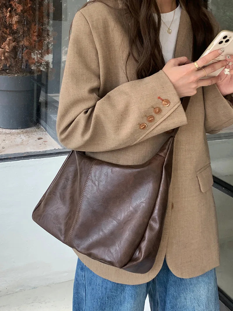 Sac bandoulière en cuir brun pour femme, élégant et tendance, parfait pour un look quotidien chic.