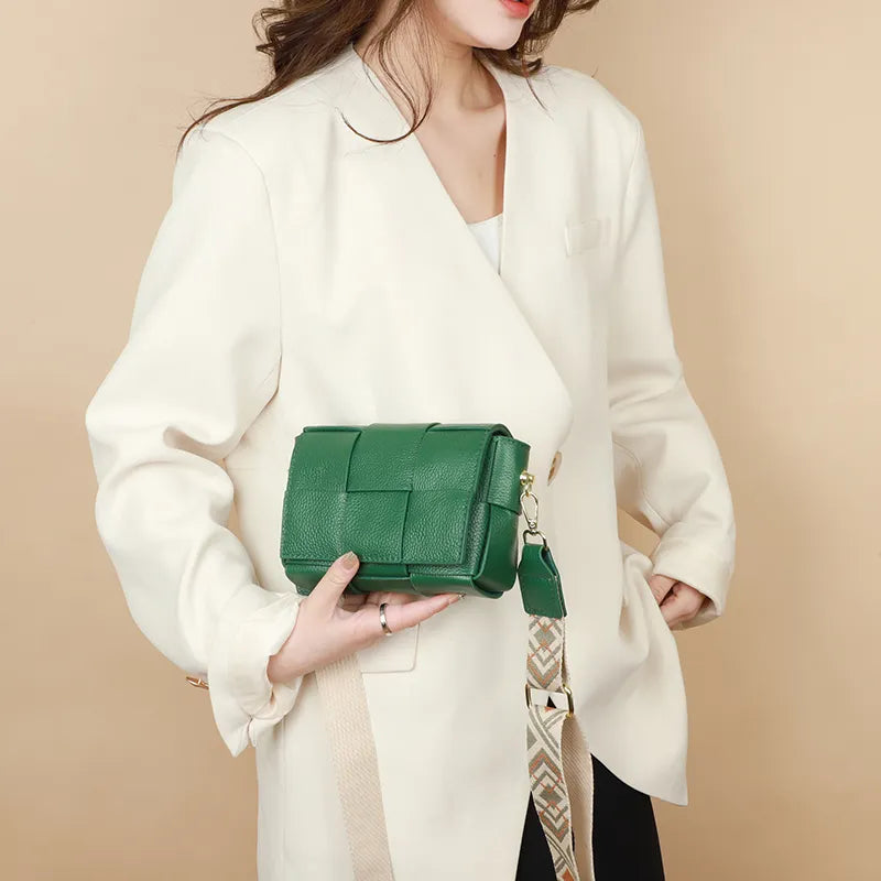 Sac bandoulière compact en cuir vert, avec détail de fermeture et bandoulière réglable pour femmes.