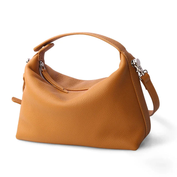 Sac femme en cuir grainé, bandoulière ajustable, chic et fonctionnel pour le voyage pratique.