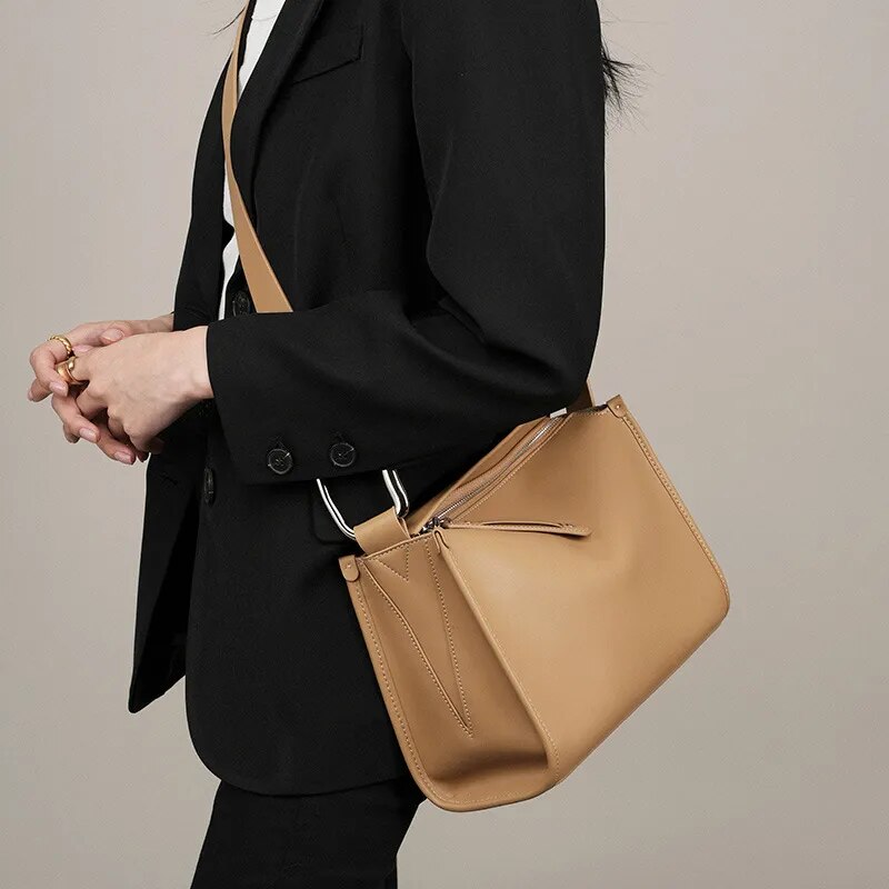 Sac bandoulière en cuir camel, parfait pour un look féminin et raffiné.