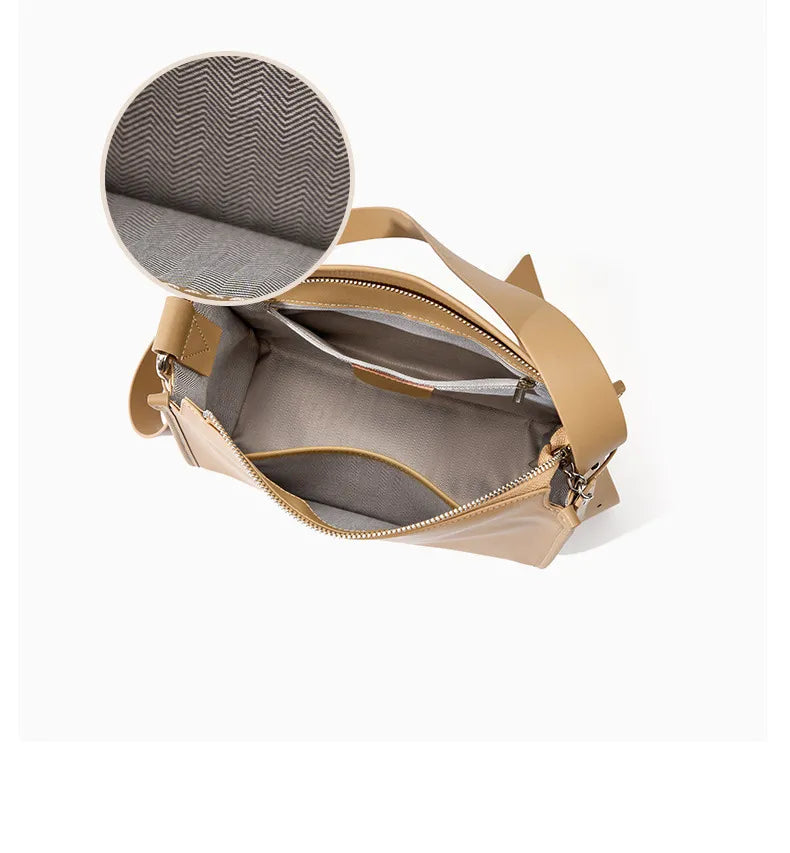 Sac en cuir beige polyvalent, chic et pratique, avec fine bandoulière ajustable.