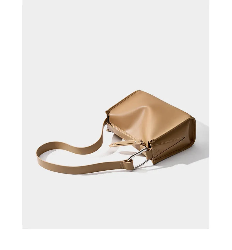 Détail d'un sac bandoulière femme en cuir camel, texture et finition impeccables.