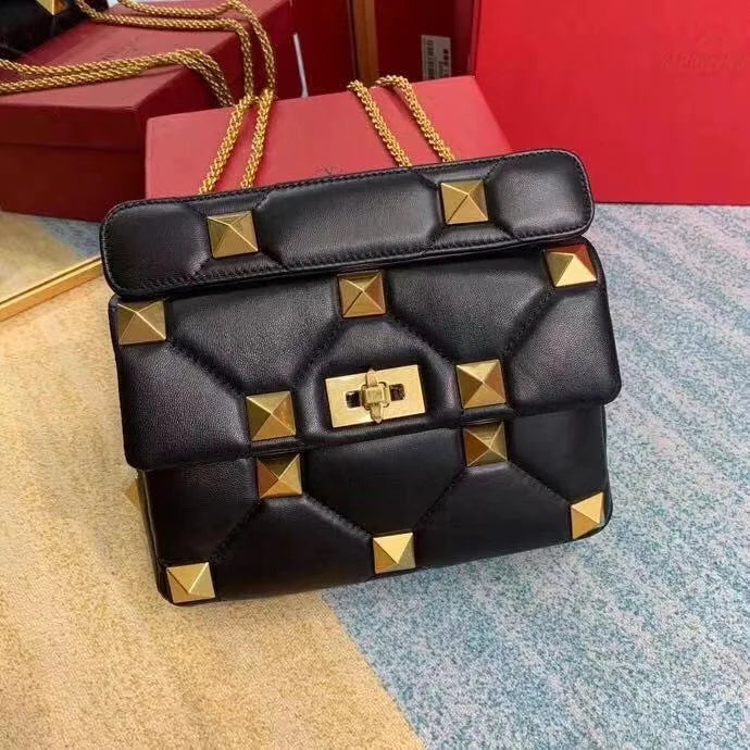Sac cuir noir pour femme, muni de clous discrets et d'une bandoulière chaîne pratique