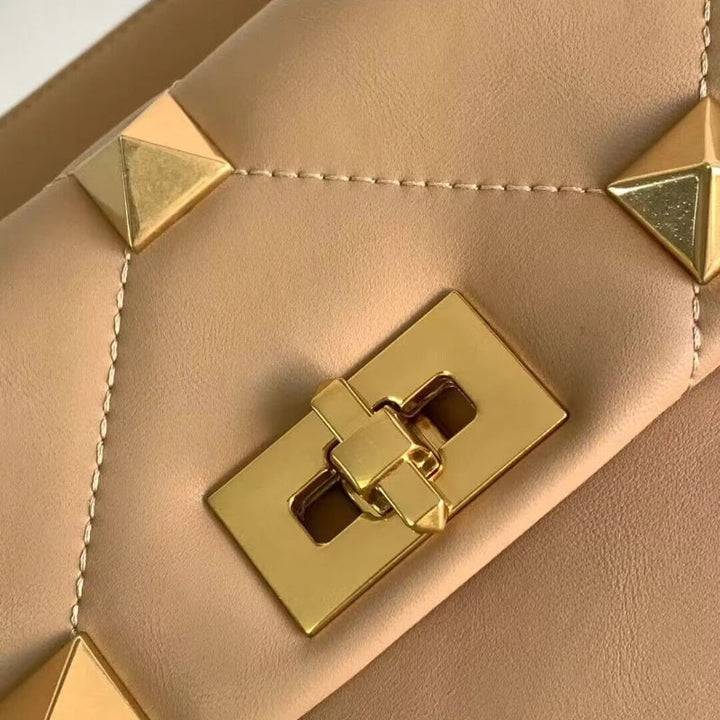 Sac bandoulière femme, en cuir marron, porté épaule, style chic et moderne avec clous