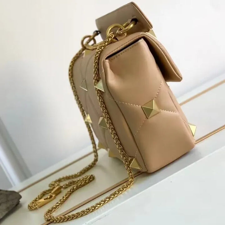 Gros plan sur les clous argentés du sac bandoulière en cuir noir, accessoire mode