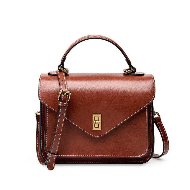 Sac bandoulière femme en cuir noir, vue rapprochée du rabat et texture du cuir grainé