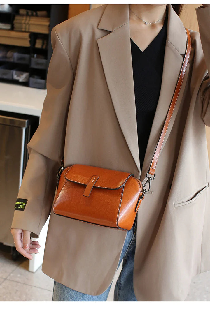 Femme élégante portant un sac bandoulière en cuir PU marron camel. Accessoire mode parfait pour un style chic et pratique.