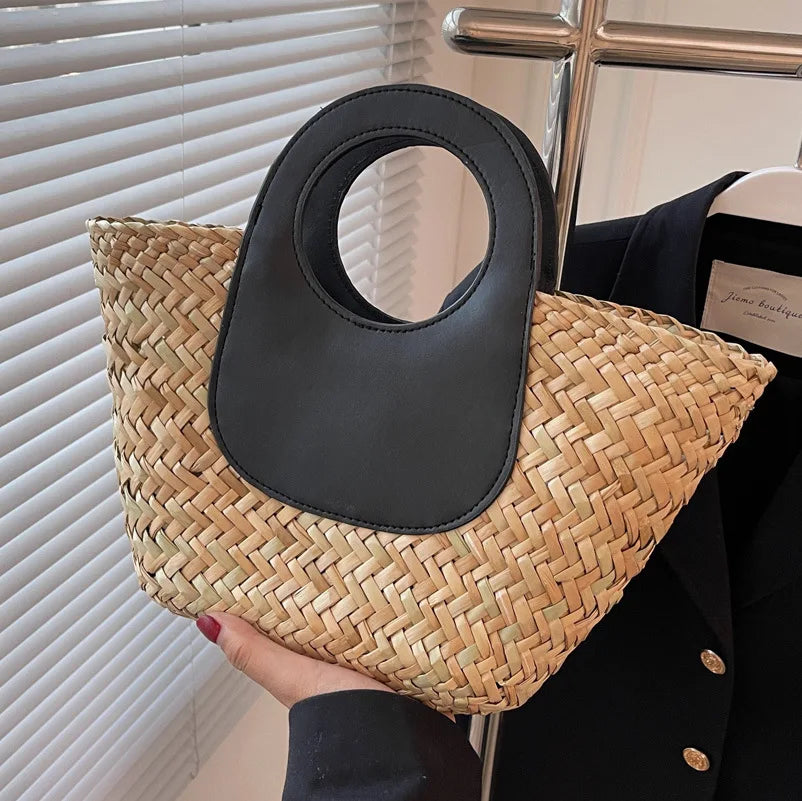 Sac bandoulière élégant pour femme, paille naturelle et détails en similicuir noir, accessoire chic.