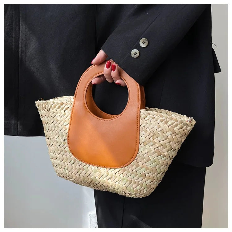 Composition d'accessoires avec un sac bandoulière en paille et similicuir, lunettes de soleil, chapeau.