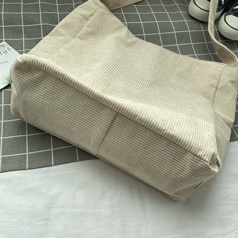 Sac bandoulière femme en velours côtelé avec fermeture pratique, accessoire féminin et stylé.