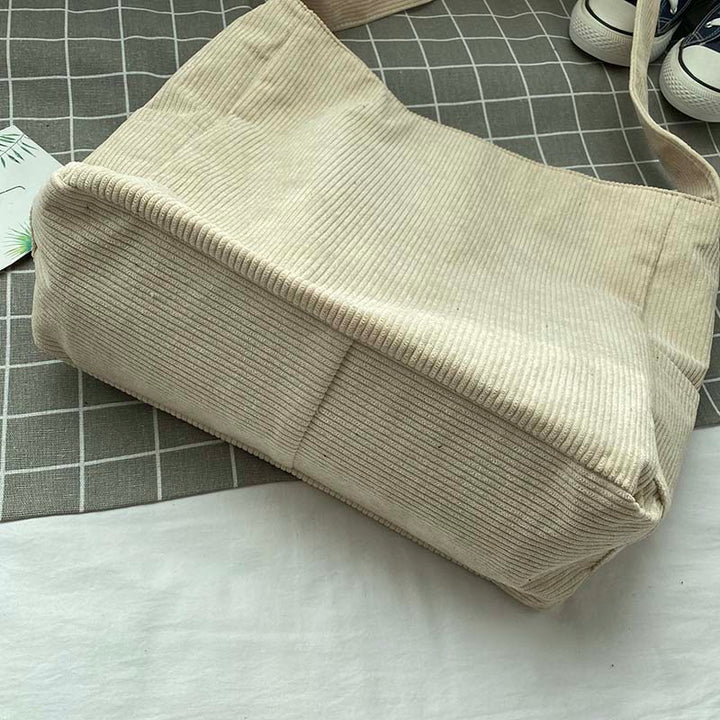 Sac bandoulière femme en velours côtelé avec fermeture pratique, accessoire féminin et stylé.