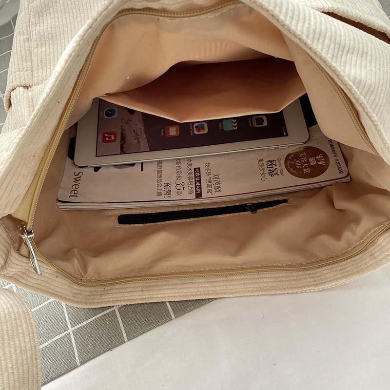 Gros plan sur la texture douce du velours côtelé de ce sac bandoulière femme, style vintage.