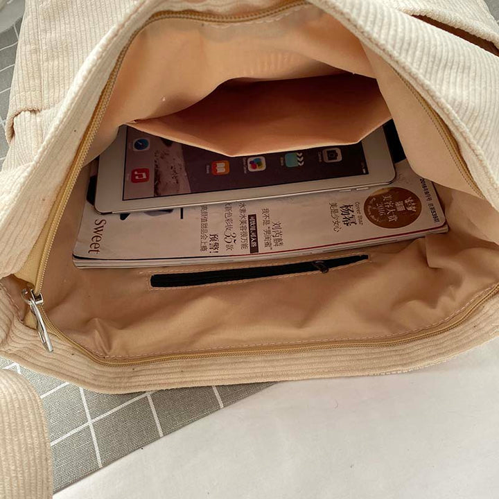 Gros plan sur la texture douce du velours côtelé de ce sac bandoulière femme, style vintage.