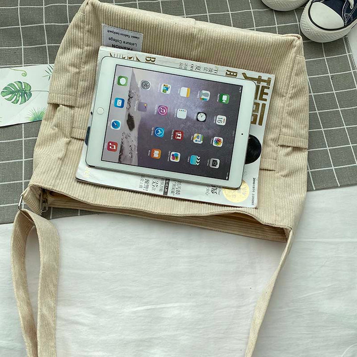 Sac bandoulière femme en velours côtelé porté avec élégance, parfait pour un look urbain chic.
