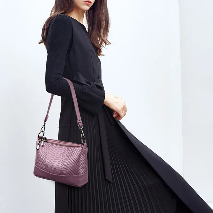 Accessoire féminin: sac bandoulière en simili cuir effet crocodile, noir brillant et élégant.