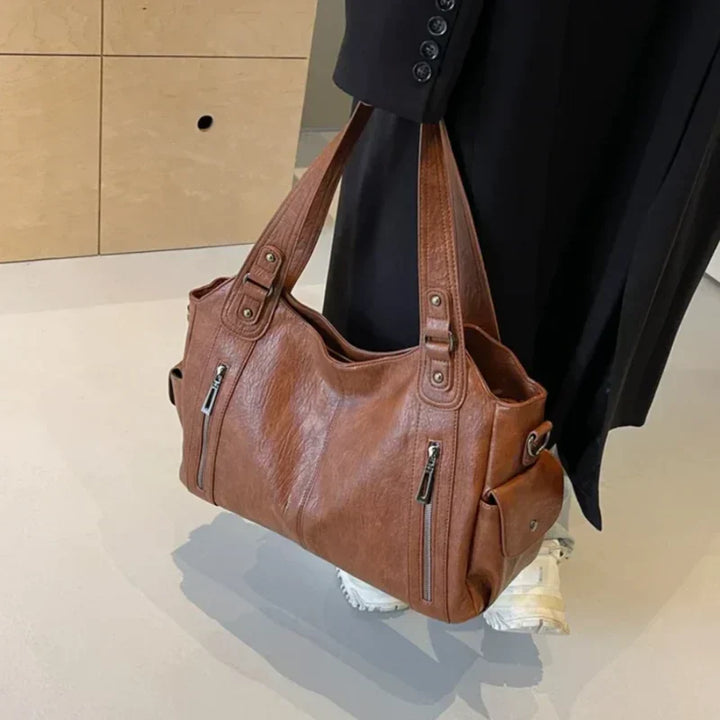 Sac bandoulière femme noir, cuir synthétique, élégant et ajustable. Un accessoire mode essentiel.