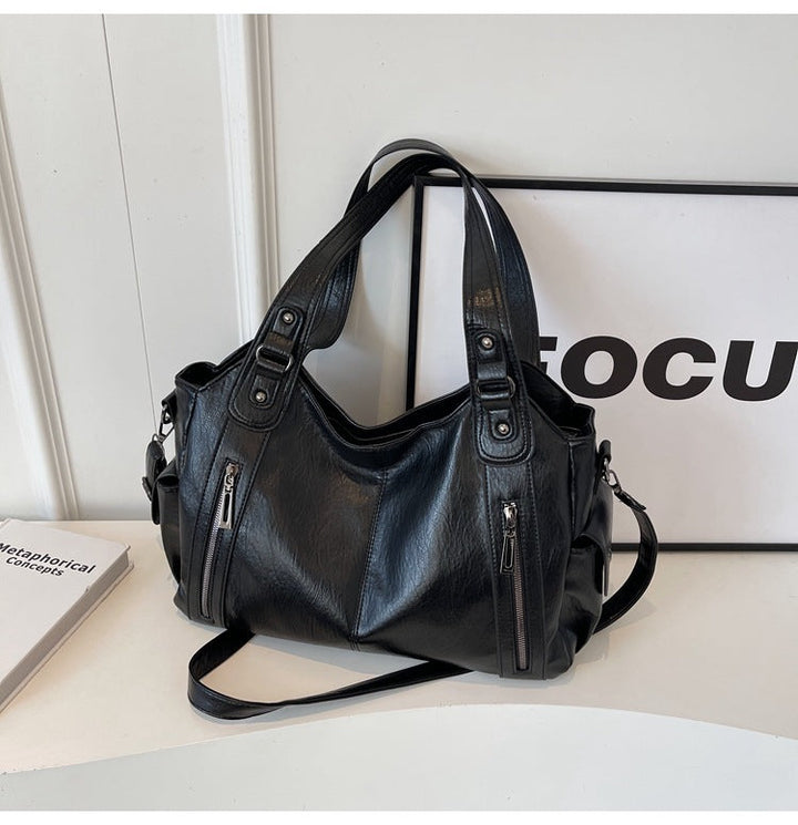 Élégant sac bandoulière noir pour femme, cuir synthétique souple, accessoire mode indispensable.