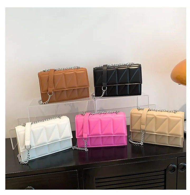 Sac femme noir, bandoulière ornée d'une chaîne, un accessoire mode très tendance