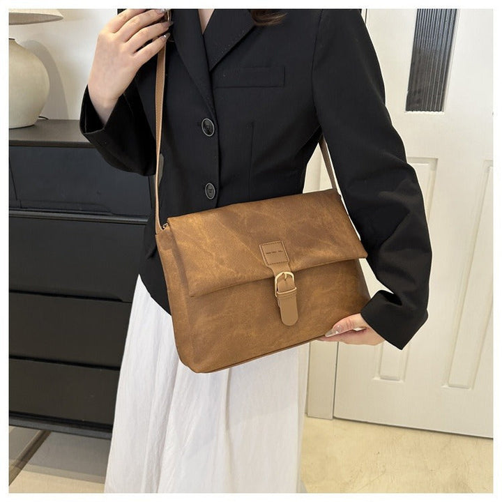 Détail du sac à bandoulière femme en cuir synthétique, texture lisse. Design minimaliste, parfait accessoire mode.
