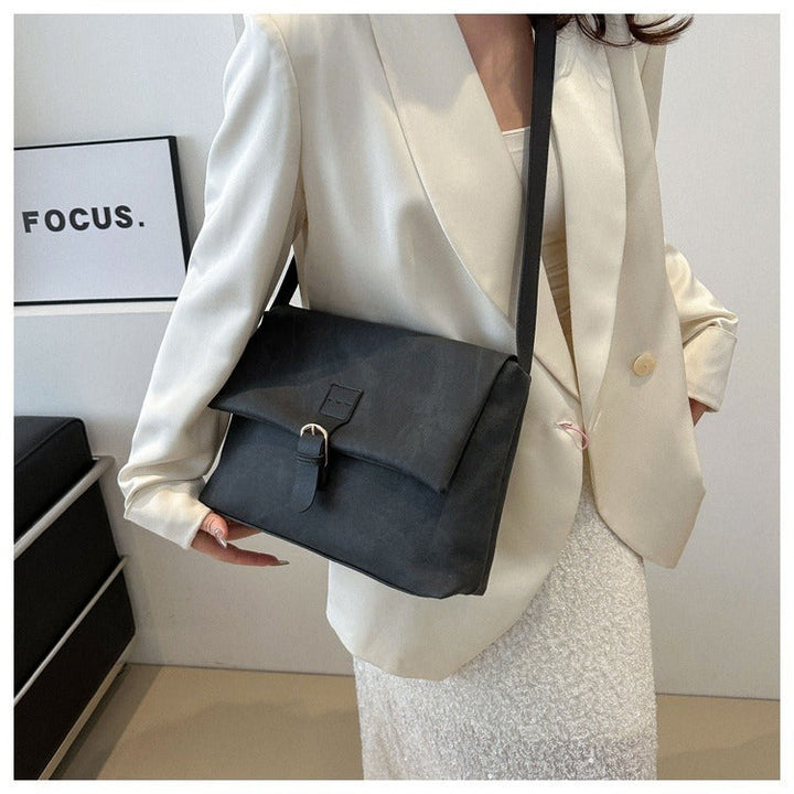 Femme portant un sac à bandoulière minimaliste élégant. Cuir synthétique, idéal pour un look quotidien polyvalent.