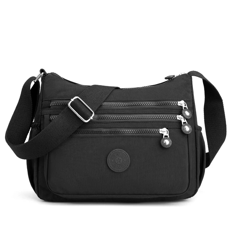 Sac bandoulière femme de voyage compact et organisé, en nylon résistant à l'eau.