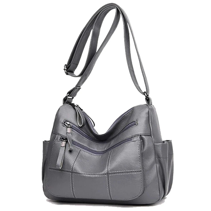 Accessoire femme: Sac à bandoulière Nexis gris, similicuir souple, parfait pour un look décontracté chic.