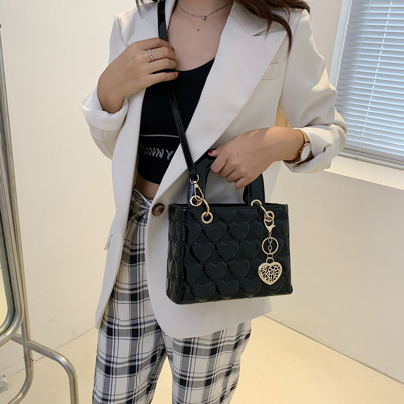 Sac bandoulière élégant noir brillant, pour femme, doté d'une texture raffinée et d'un design chic.