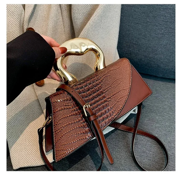 Sac bandoulière femme effet croco noir avec éclairage, mettant en valeur son élégance