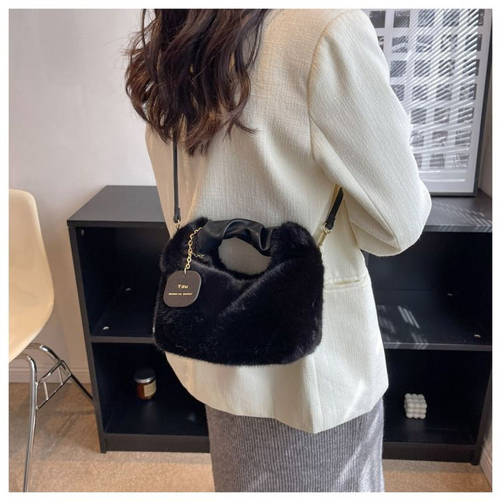Sac femme bandoulière noir en fausse fourrure douce, un accessoire mode tendance pour la saison froide.