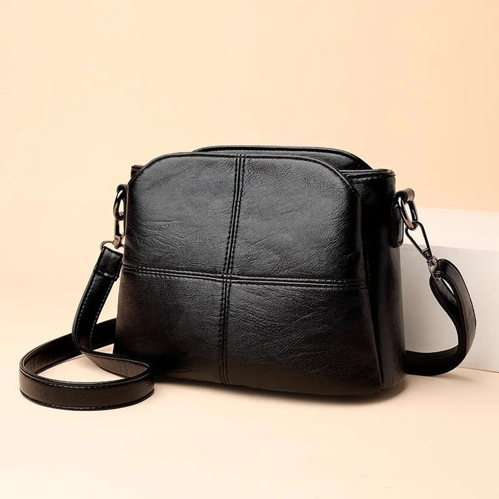 Sac bandoulière femme noir élégant en similicuir, style compact et organisé pour un look chic au quotidien.